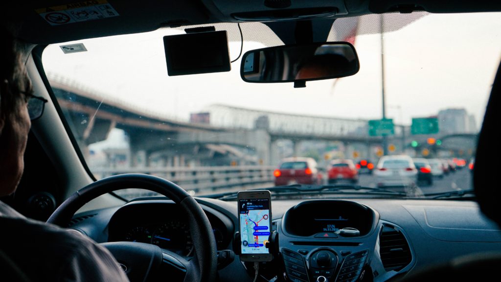 uber driver in traffic with app open